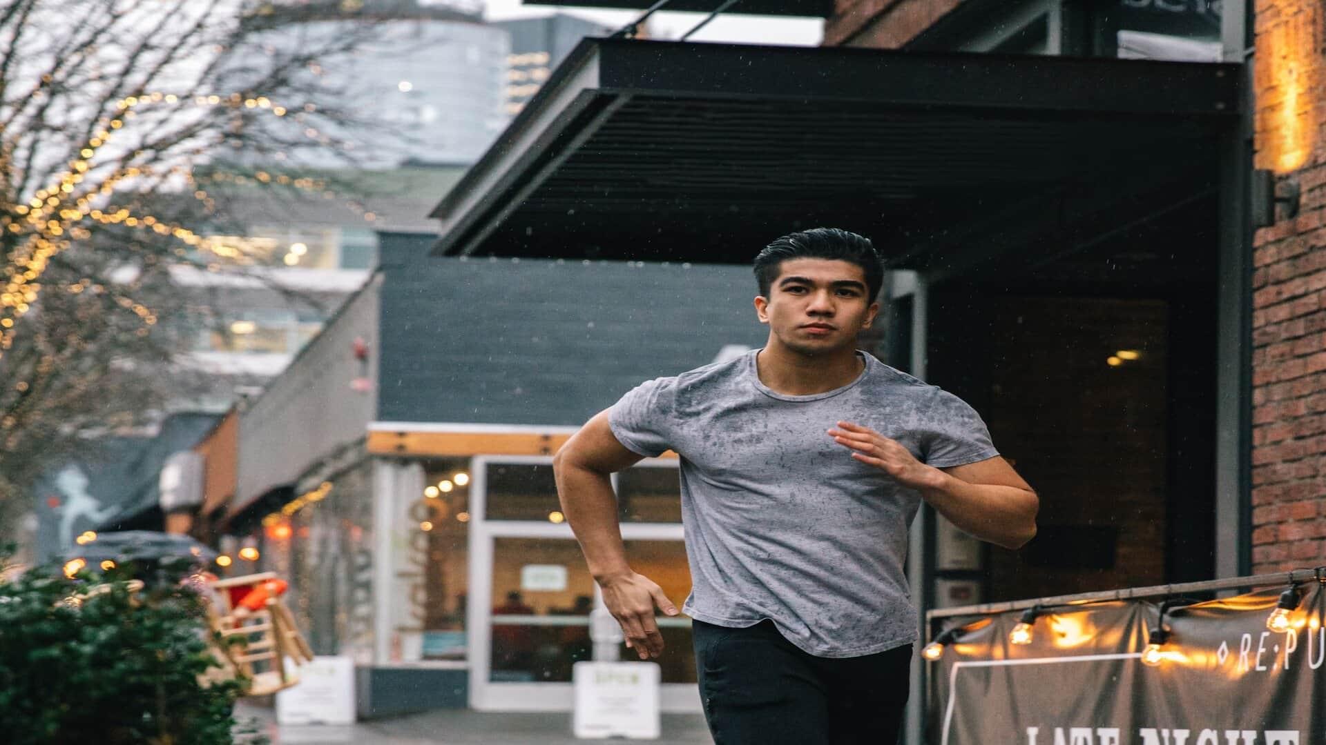 Man in grey tshirt running in the rain in Seattle