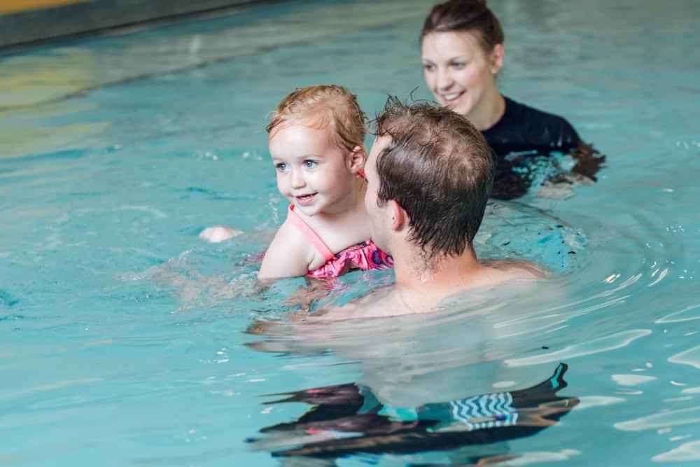 Two adults teaching a youngster how to swim at PRO Club Aquatics