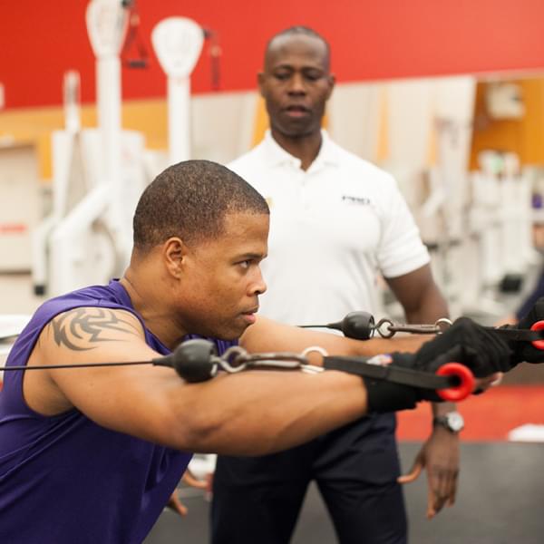 Personal Trainer at PRO Club overseeing a client during a workout