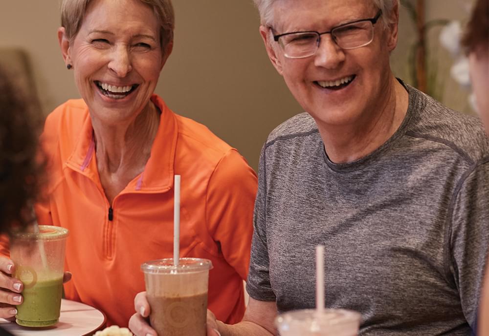 An elderly couple enjoying healthy shakes from the Pro Club Cafe