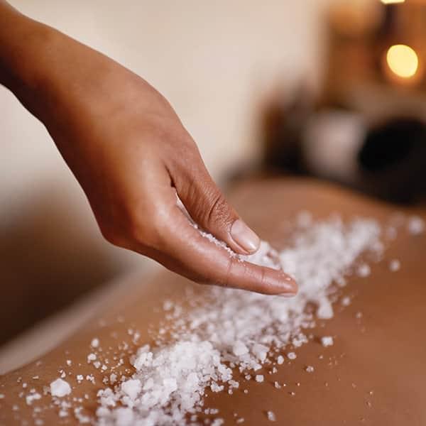 A woman getting a sea salt scrub spa treatment at Pro Club's Spa