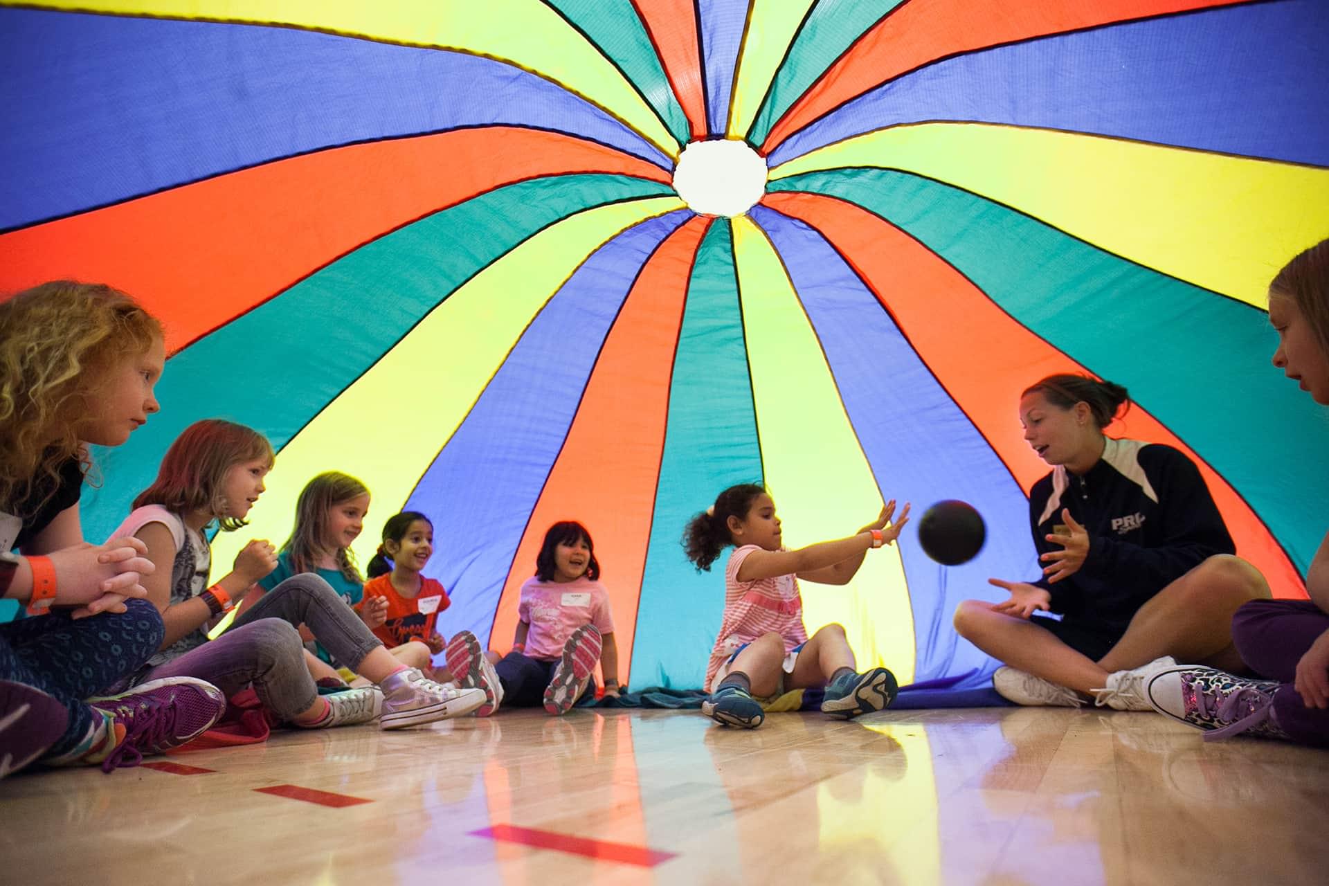 Groups of kids playing in a parachute
