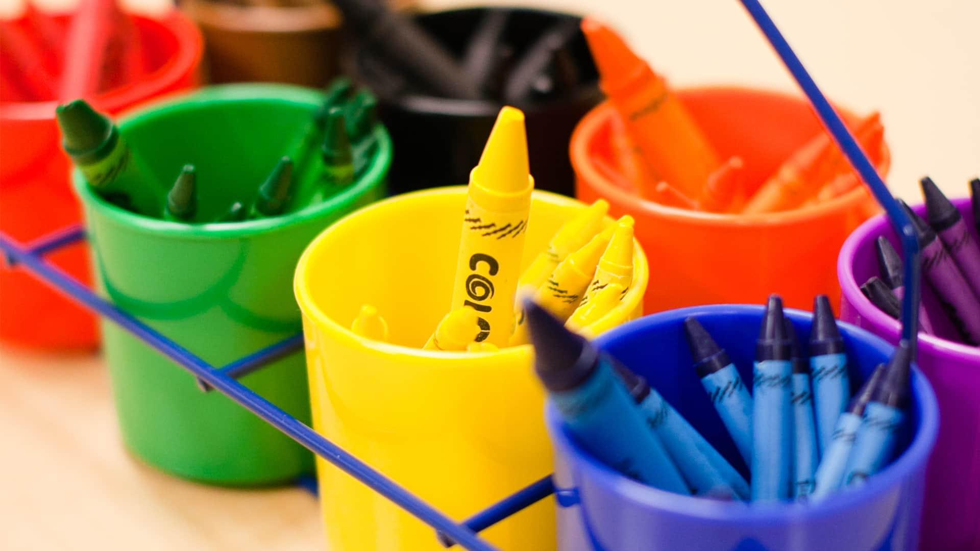 Eight cups holding colored crayons