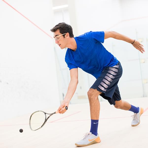 An adult taking a squash lesson with a PRO squash instructor