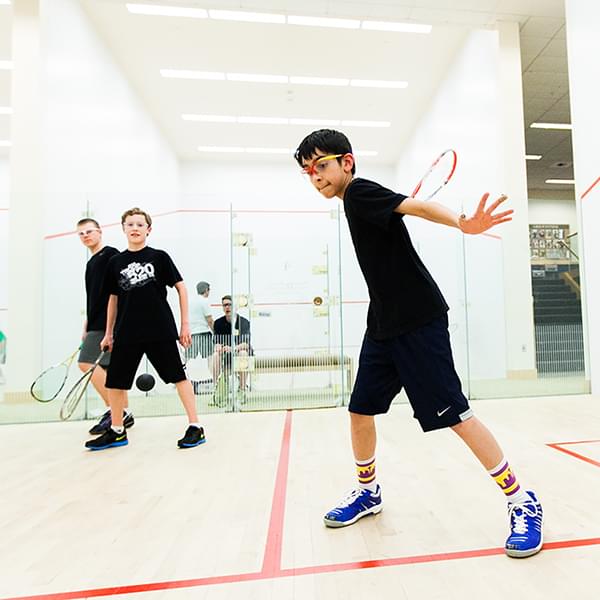 Three teenagers playing squash at PRO